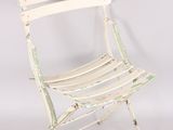 white metal folding chair against a white background