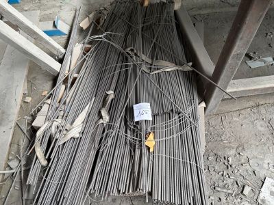 un tas de barres d'acier posé par terre à côté d'une échelle