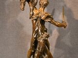 bronze statue of a woman holding a sword and a bird in her hand