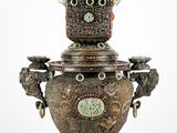 un vase en argent surmonté d'une horloge