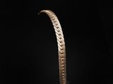 a close up of a gold bracelet on a black background