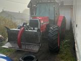 un tracteur garé à côté d'une voiture