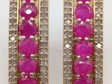 a pair of pink and white stone earrings on a white surface
