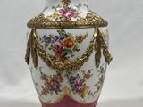 a white vase with a pink and gold decoration on it