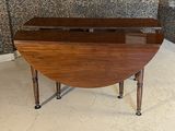 a wooden table with a glass top on a tiled floor