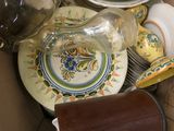 a box full of plates and cups and a glass bottle