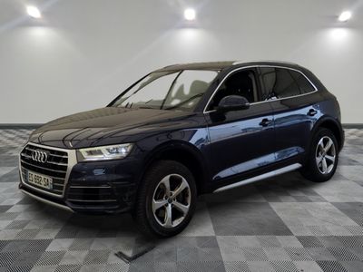 un SUV Audi bleu garé sur un sol à damier dans un showroom