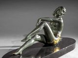 an image of a bronze statue of a woman sitting on a marble base