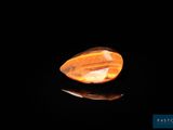 a yellow quartz stone on a black surface