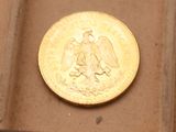 une pièce d'or posée sur une boîte marron