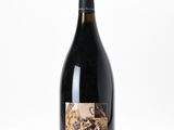 the bottle of wine is sitting on a white surface