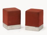 une paire de poufs cubiques rouges avec des pieds argentés sur fond blanc