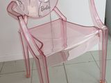 une chaise en plastique rose avec un miroir sur le dossier