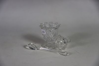 a glass vase with a spoon and a spoon rest on a table