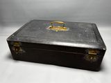 a black suitcase with a gold handle sitting on a white surface
