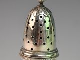 an antique silver pepper shaker with a pineapple on the top