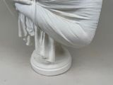 a white statue of a woman wrapped in a blanket