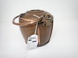 un sac en papier brun muni d'une étiquette, posé sur une surface blanche