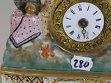 a figurine of a man and woman sitting on top of a clock