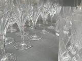 a lot of wine glasses and a pitcher on a table