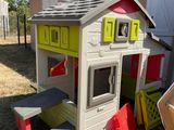 a little house with a picnic table in the yard