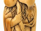 an old carved figurine of an angel holding a baby