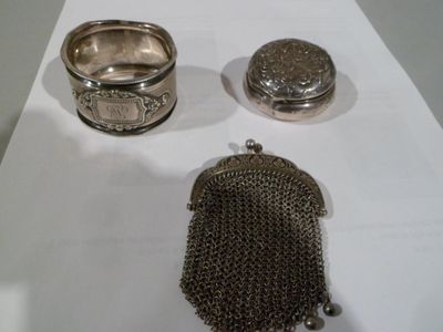 un porte-monnaie en argent et une bague en argent posés sur une table