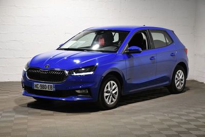 une voiture bleue garée dans un garage au sol en damier