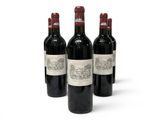 three bottles of red wine are lined up on a white surface