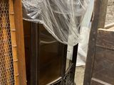 a wooden cabinet in the middle of a room with a plastic covering over it