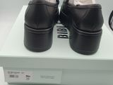 black leather shoes with white soles on a white box