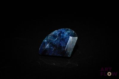 a close up of a blue stone on a black surface