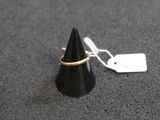 un petit cône noir orné d'un anneau doré