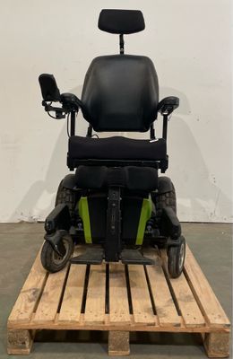 une trottinette électrique posée sur une palette devant un mur blanc