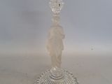 un bougeoir en verre transparent orné d'une statuette