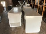 two white refrigerators sitting in a room next to each other
