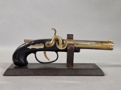 a close up of a toy gun on a stand on a white surface
