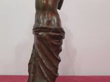 bronze statue of a woman with her back turned to the side