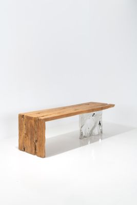 Le banc est en bois et est surmonté d'une plaque de marbre.
