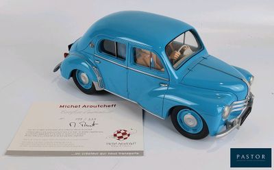 une petite voiture bleue posée à côté d'une carte