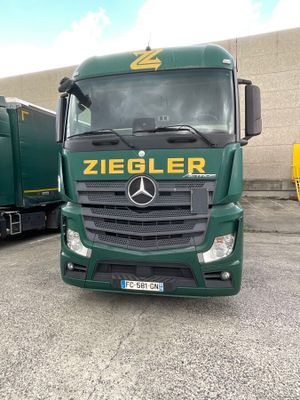 a green truck that is parked in a parking lot