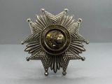 un gros plan d'une broche en argent et en or posée sur une table