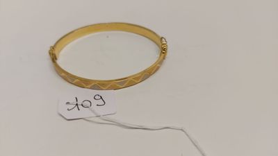 Gros plan sur un bracelet en or portant une étiquette