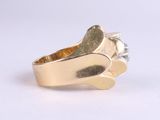 a gold ring with a diamond in it on a white surface