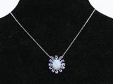 un collier composé d'une pierre d'oplite blanche entourée de cristaux violets, présenté sur un mannequin noir