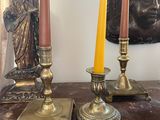 candles are sitting on a table in front of a statue