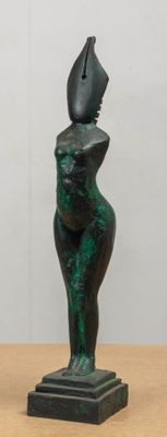 a statue of a woman sitting on top of a wooden table