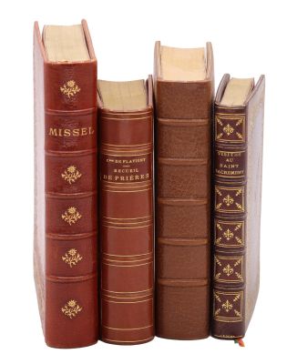 trois livres sont empilés sur une surface blanche