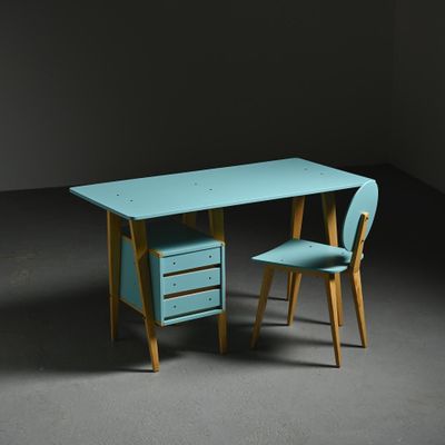 un bureau et une chaise turquoise dans une pièce sombre aux murs sombres