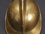 brass helmet on a black surface